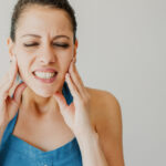 TMJ jaw-pain-lady-holding-her-jaw